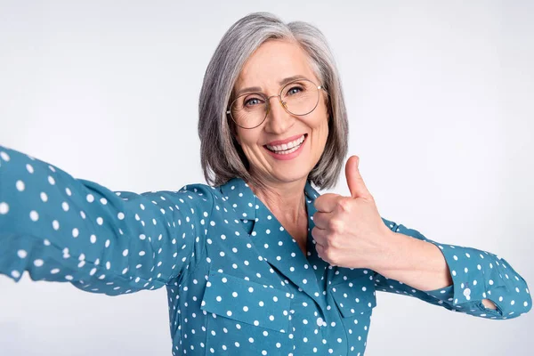 Auto-retrato de mulher de meia-idade alegre atraente mostrando negócio anúncio thumbup feito isolado sobre fundo de cor pastel cinza — Fotografia de Stock