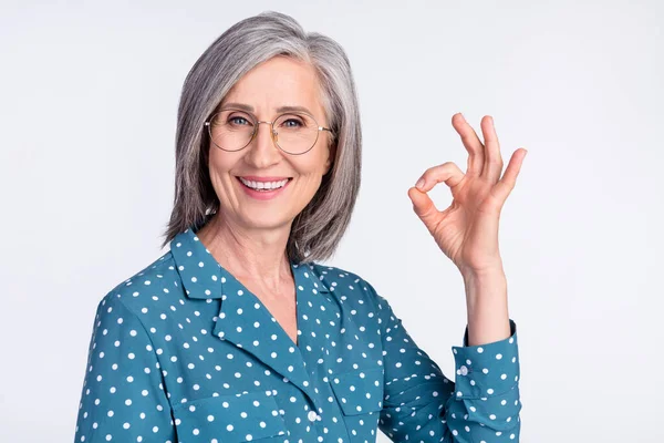 Foto porträtt av senior affärskvinna i glasögon visar okej gest leende isolerad på vit färg bakgrund — Stockfoto
