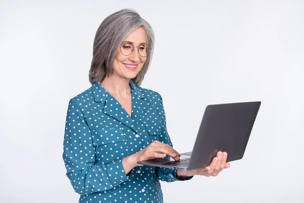 Photo of happy cheerful old woman hold computer work smile wear glasses isolated on grey color background — Stock Photo, Image