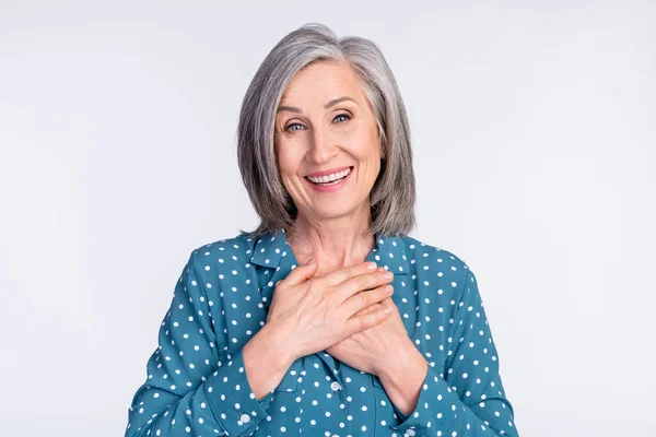 Foto ritratto della donna anziana in camicetta tratteggiata tenere le mani sul petto grato sincero isolato su sfondo di colore bianco — Foto Stock