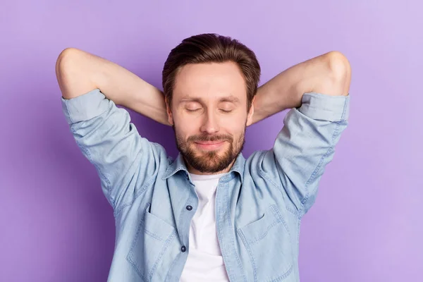 Foto van gelukkige mooie knappe man houd handen hoofd genieten ontspannen geïsoleerd op violette kleur achtergrond — Stockfoto