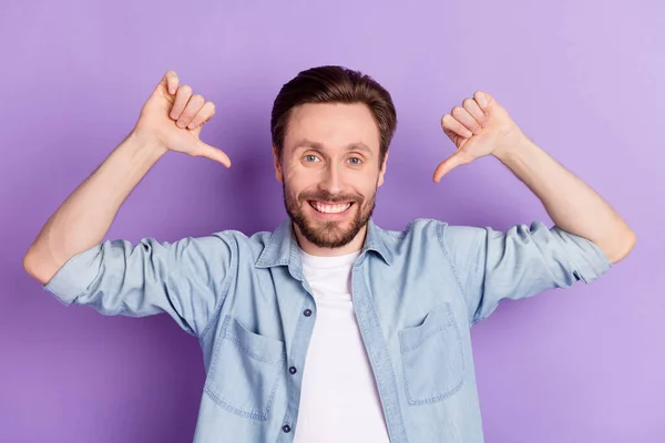 Foto van slimme zelfverzekerde jonge heer gekleed jeans outfit wijzend duimen zelf glimlachen geïsoleerde violette kleur achtergrond — Stockfoto