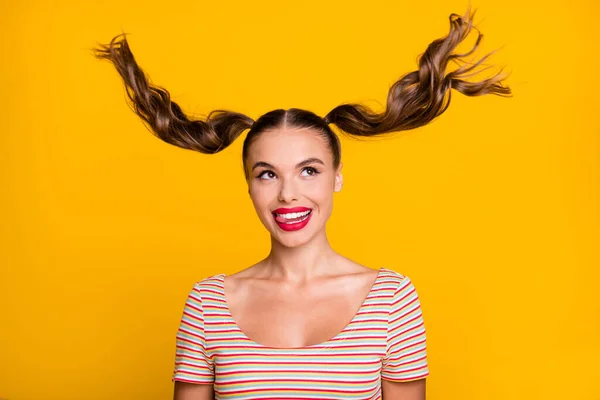 Portrait of young lovely pretty cheerful smiling positive girl with flying hair stick tongue out isolated on yellow color background — Stock Photo, Image