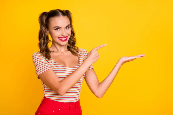 Porträt eines attraktiven, fröhlichen Mädchens, das auf der Handfläche eine Kopierfläche zeigt, Werbung isoliert auf leuchtend gelbem Hintergrund — Stockfoto