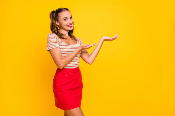 Foto de joven atractiva hermosa alegre alegre chica sonriente presente oferta anuncio aislado en el fondo de color amarillo — Foto de Stock