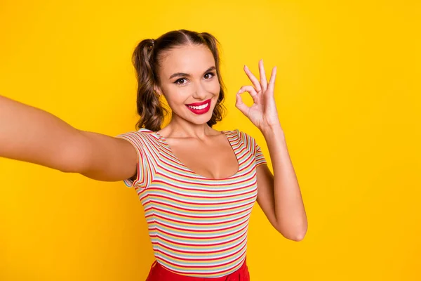 Foto von niedlichen Mädchen schießen Selfie zeigt Okey Look Kamera tragen gestreiftes Hemd isoliert gelbe Farbe Hintergrund — Stockfoto
