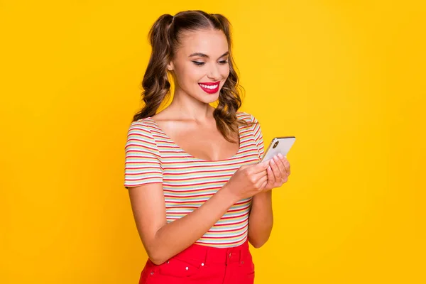 Portret van aantrekkelijke vrolijk gericht meisje met behulp van apparaat browsen media multimedia geïsoleerd over helder gele kleur achtergrond — Stockfoto