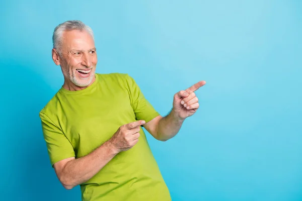 Retrato de aspecto chico envejecido indican dedos espacio vacío proposición radiante sonrisa aislada sobre fondo de color azul —  Fotos de Stock