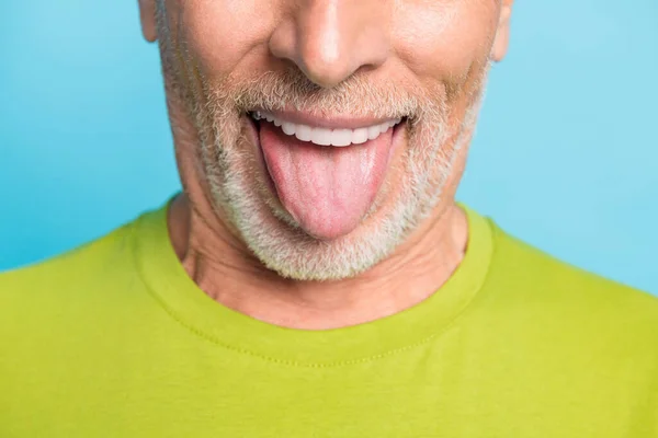 Retrato de cerca recortado de atractivo alegre barbudo barbudo hombre de pelo gris mostrando la lengua aislado sobre fondo de color azul brillante —  Fotos de Stock