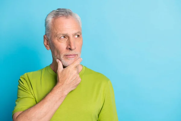 Portrait of calm focused aged guy arm on chin look interested empty space isolated on blue color background — Stock Photo, Image