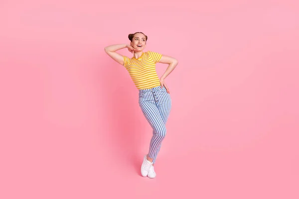 Foto em tamanho completo de otimista agradável morena senhora olhar espaço vazio desgaste t-shirt calças isoladas no fundo rosa — Fotografia de Stock