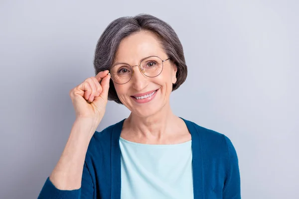 Retrato de mujer atractiva alegre inteligente de pelo gris intelectual tocando especificaciones aisladas sobre fondo de color pastel gris — Foto de Stock