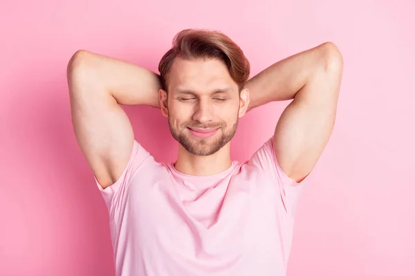 Foto van schattige charmante jonge man dragen casual kleding armen achter hoofd gesloten ogen hebben rust glimlachen geïsoleerde roze kleur achtergrond — Stockfoto