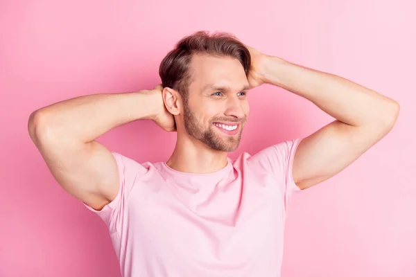 Foto av attraktiv söt gentleman klädd casual t-shirt leende armar huvud ser tomt utrymme isolerad rosa färg bakgrund — Stockfoto