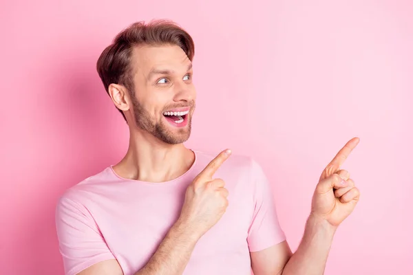 Φωτογραφία του παιδαριώδη εντυπωσιασμένος κύριος ντυμένος casual t-shirt χαμογελώντας αναζητούν κενό χώρο απομονωμένο ροζ χρώμα φόντο — Φωτογραφία Αρχείου