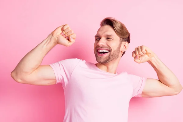 Foto van zoete sterke jonge man dragen casual kleding dansen op zoek lege ruimte tonen spieren geïsoleerde roze kleur achtergrond — Stockfoto