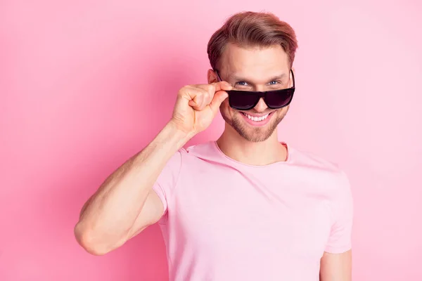 Foto van charmante aantrekkelijke jonge heer gekleed casual t-shirt arm donker oogkledij glimlachen geïsoleerde roze kleur achtergrond — Stockfoto