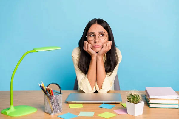 Retrato de menina aborrecida atraente preparando o teste de exame de tarefa de casa isolado sobre fundo de cor azul brilhante — Fotografia de Stock