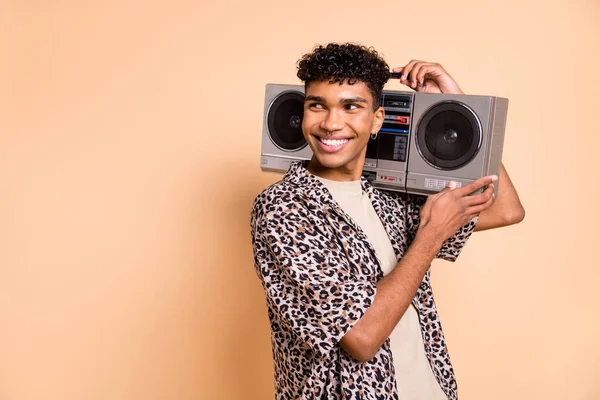 Foto de tipo optimista morena escuchar boom box look espacio vacío usar pantalones de camisa modernos aislados sobre fondo de color beige —  Fotos de Stock