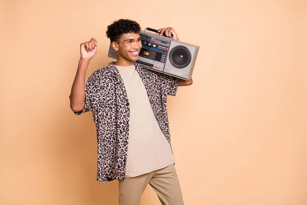 Foto av brunett optimistisk kille lyssna bom box bära modern skjorta byxor isolerad på beige färg bakgrund — Stockfoto