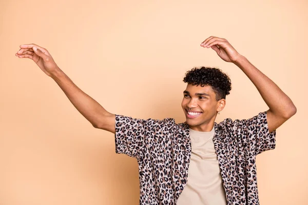 Foto di bruno ottimistico ragazzo danza braccia fino indossare camicia moderna isolato su sfondo di colore beige — Foto Stock