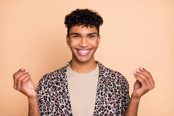 Retrato de peinado rizado alegre piel oscura chico manos dedos muestran dinero gesto aislado sobre fondo de color beige — Foto de Stock