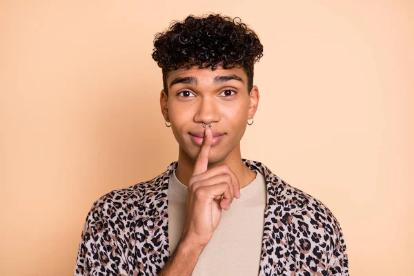 Photo of handsome dark skin guy finger covering lips mouth do not talk look camera isolated on beige color background — Stock Photo, Image