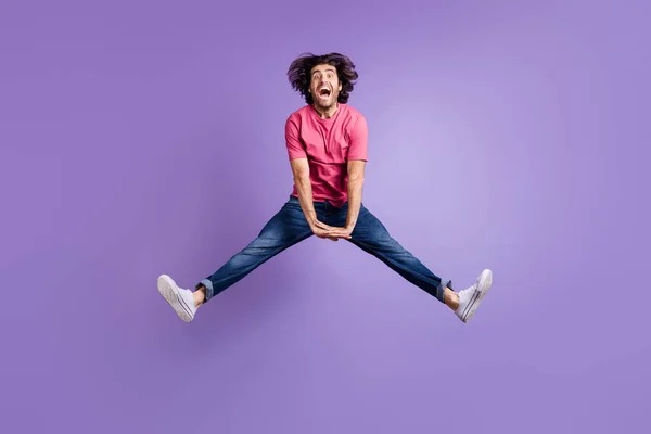 Foto panjang lengkap gila pemuda bersemangat berpakaian pink melompat tinggi sisi terisolasi ungu latar belakang warna — Stok Foto