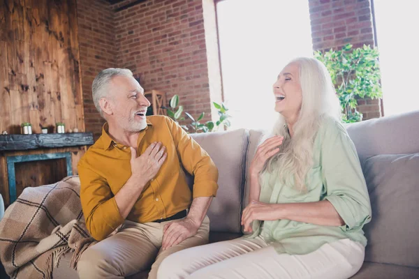 Retrato de pareja alegre atractiva sentada en el sofá hablando divirtiéndose riéndose en el moderno loft interior industrial hogar interior — Foto de Stock