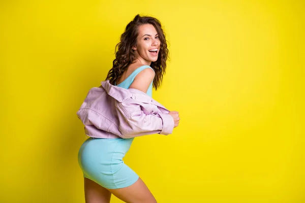 Profil sida vy av attraktiva tunna glada vågiga hår flicka poserar med roliga kopia utrymme isolerad över ljusa gula färg bakgrund — Stockfoto