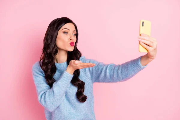 Foto de bonita dama sostener teléfono palma tomar selfie enviar aire beso desgaste azul suéter aislado color rosa fondo — Foto de Stock