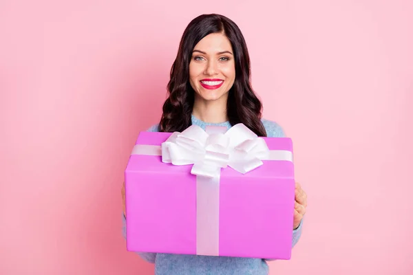 Foto de alegre niña bastante joven sostener caja de sorpresa sonrisa de dientes usar jersey azul aislado color rosa fondo —  Fotos de Stock
