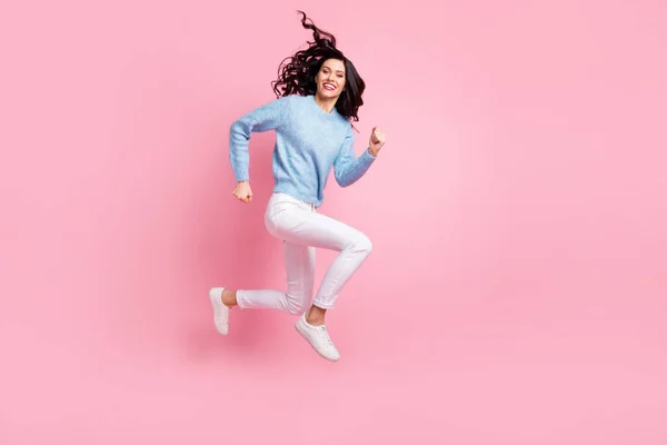 フル長さプロフィール写真のクレイジー精力的な女の子ジャンプ実行見てカメラ着用青セーター隔離されたピンク色の背景 — ストック写真