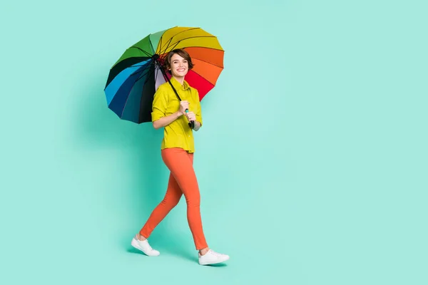Longitud completa tamaño del cuerpo foto de la niña sonriendo bajo paraguas colorido aislado brillante color verde azulado fondo — Foto de Stock