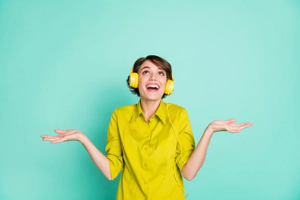 Portret van aantrekkelijke vrolijke dromerige meisje met plezier luisteren muziek kijken omhoog geïsoleerd op helder blauwe kleur achtergrond — Stockfoto