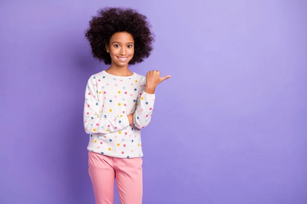 Foto de bonita piel oscura chica morena punto copyspace usar pantalones de color rosa suéter blanco aislado sobre fondo de color violeta —  Fotos de Stock