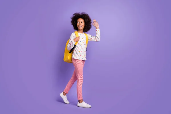 Foto lateral de perfil de cuerpo completo de la morena afroamericana niña ir copyspace ola usar pantalones de color rosa aislados en el fondo de color púrpura —  Fotos de Stock