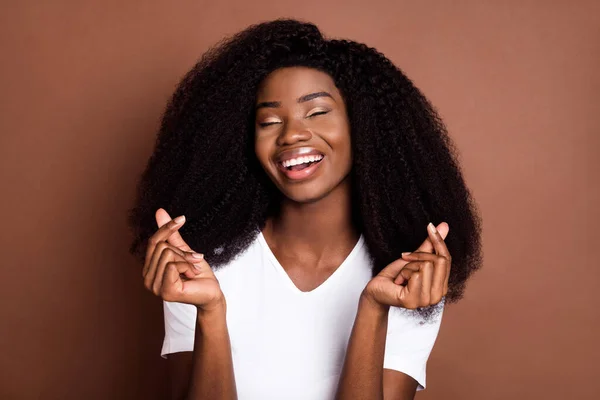 Foto retrato de menina encaracolado sorrindo alegrou mostrando gesto do coração coreano pedindo dinheiro isolado em pastel marrom fundo cor pastel — Fotografia de Stock