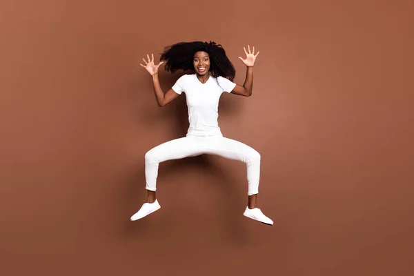 Foto corpo pieno di giovane ragazza nera eccitato felice sorriso positivo saltare isolato su sfondo di colore marrone — Foto Stock