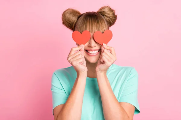 Retrato de encantador menina sorriso braços segurar coração símbolo cartão cobrindo olhos isolados no fundo cor-de-rosa — Fotografia de Stock