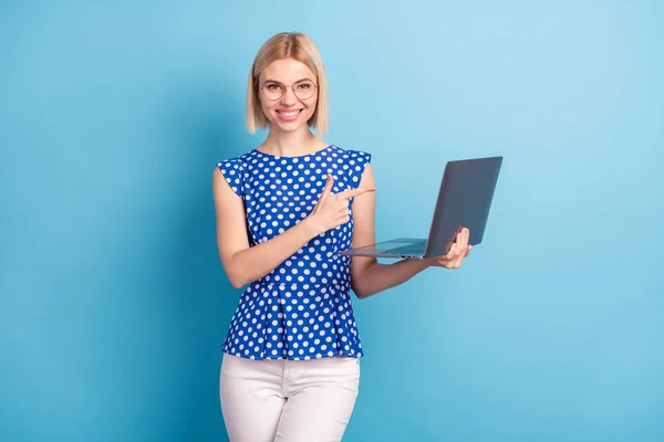 Foto av ung attraktiv flicka glad positiv leende peka finger laptop annonser promo välja isolerad över blå färg bakgrund — Stockfoto