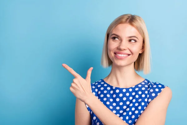 Foto di giovane ragazza felice sorriso positivo sguardo indicare dito vuoto spazio annunci decisione promo isolato su sfondo di colore blu — Foto Stock
