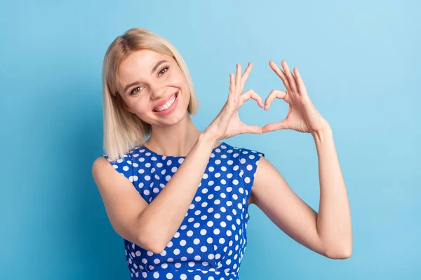 Foto gadis muda yang menarik senyum positif menunjukkan tangan simbol hati terisolasi atas warna biru latar belakang — Stok Foto