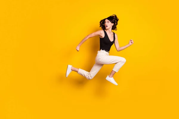 Повна довжина профілю тіла фотографія божевільної жінки, що стрибає, повертаючись назад ізольовано яскраво-жовтий кольоровий фон — стокове фото