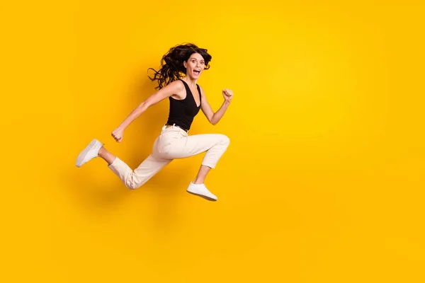 フル丈ボディサイズサイドプロフィール写真の女性ジャンプ陽気に実行上の販売隔離された鮮やかな黄色の背景 — ストック写真