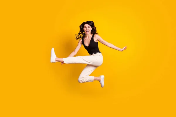 Фотографія повного розміру тіла жінки, що стрибає, вдаючи, що грає на гітарі грайливий дитячий ізольований яскраво-жовтий кольоровий фон — стокове фото