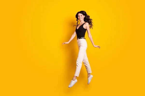 Foto de tamaño corporal de longitud completa de la mujer divertida saltando con gracia como bailarina aislada en el fondo de color amarillo brillante —  Fotos de Stock