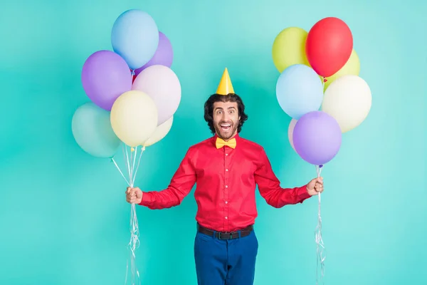 Foto de feliz animado bom humor bonito cavalheiro segurar balões celebrar aniversário isolado no fundo cor teal — Fotografia de Stock