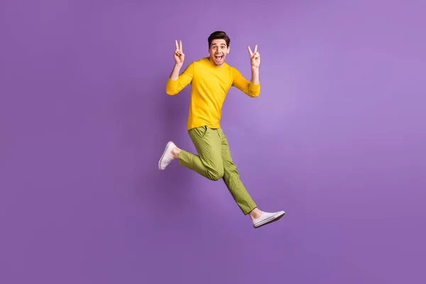 Full size profile side photo of young man happy positive smile jump show peace cool v-sign isolated over purple color background — Stock Photo, Image