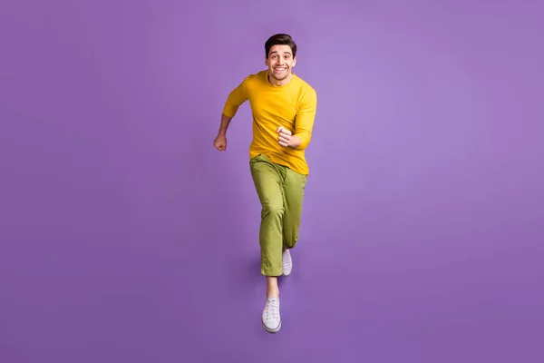 Полное тело фото молодого человека счастливый позитивный прыжок улыбка идти идти бежать скорость, изолированные на фиолетовый цвет фона — стоковое фото